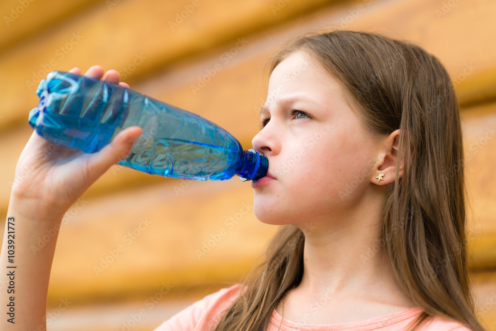 Girl drinking water outdoors Girl drinking water outdoors