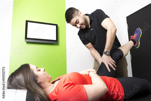 Male Osteopath Treating Female Patient With Hip Problem