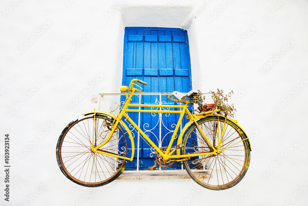 Old bicycle with a basket leaning against a wall in Greece