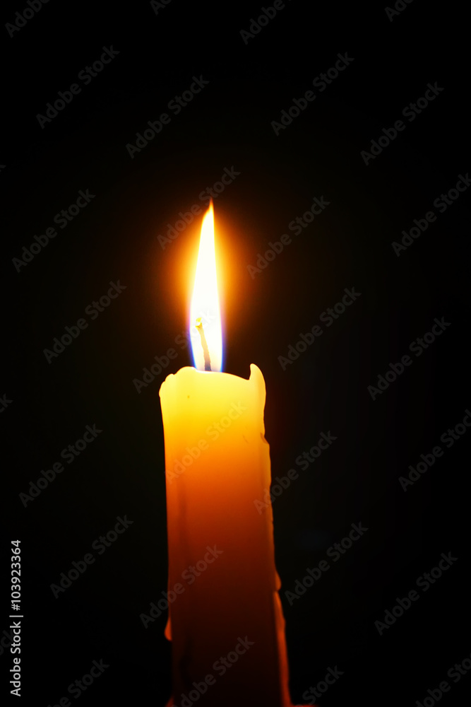burning candle on a black background burning candle on a black background