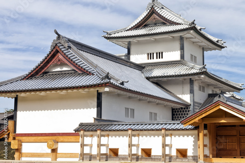 Japanese hilltop castle in historic city of Kanazawa, with watchtower covered by lead whitish roof tiles