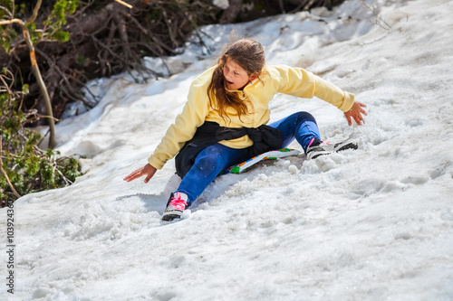 girl is sliding from a snowy mountain