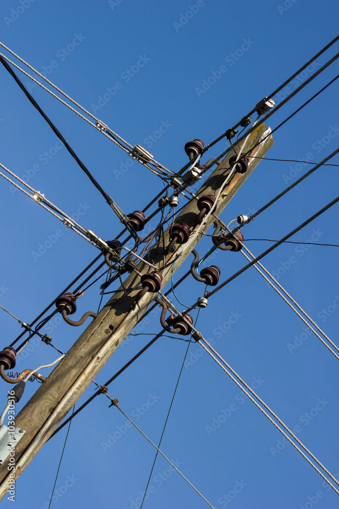 Electricity pole with a bunch of wires against blue sky Electricity pole with a bunch of wires against blue sky