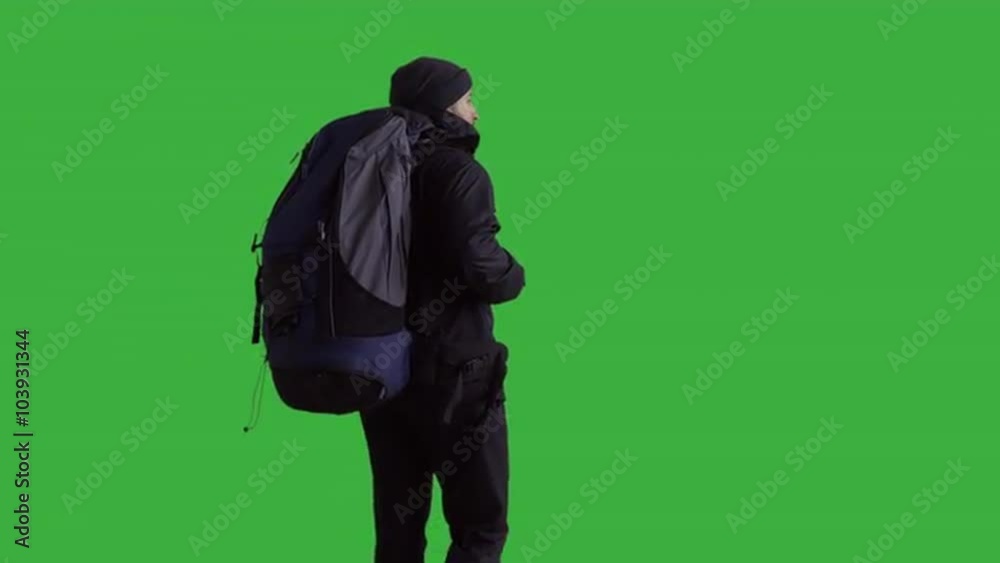 Young male hiker with a backpack looking into the distance - green screen. Prores 422HQ 4K UHD 60FPS slow motion shot. Shot with Blackmagic URSA Mini