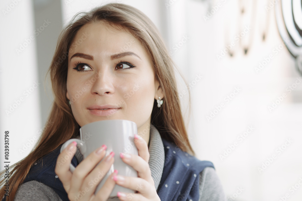 Attractive young woman sitting in a coffee shop at window Attractive young woman sitting in a coffee shop at window