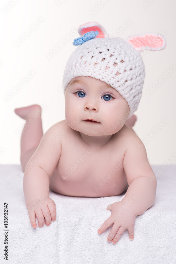 baby lying down in white knitted hat with ears bunny baby lying down in white knitted hat with ears bunny