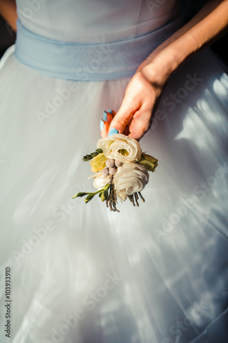 gorgeous stylish elegant bride and bridesmaid holding colorful boutonniere