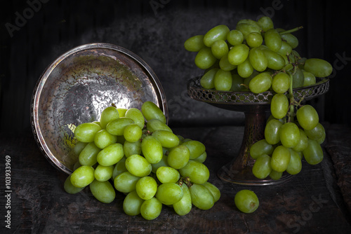 Green grapes on dark background - vintage, moody style