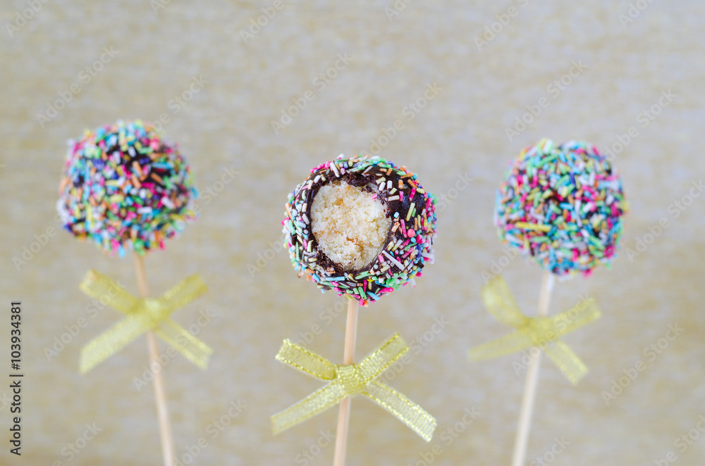 Cake pops with sprinkles on golden background Cake pops with sprinkles on golden background