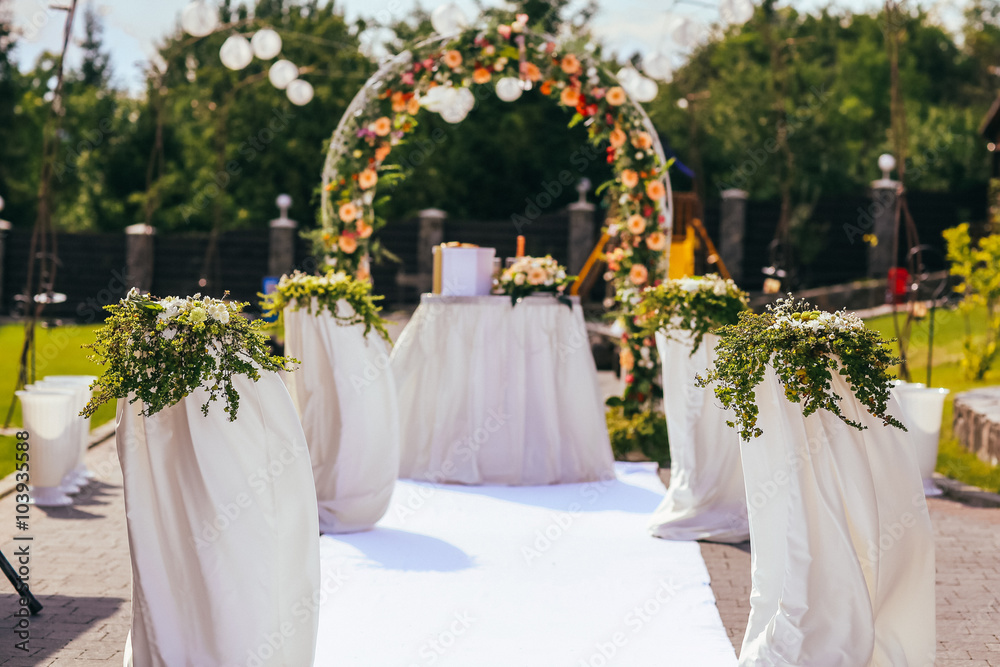 wedding ceremony arch with roses in the summer day