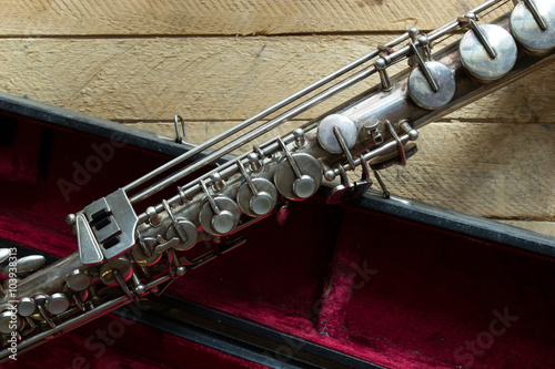 саксофон сопрано на деревянном фоне