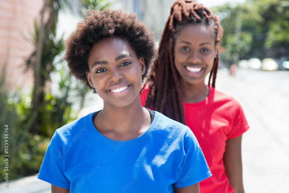 Zwei fröhliche Frauen aus Afrika in bunten Shirts Zwei fröhliche Frauen aus Afrika in bunten Shirts