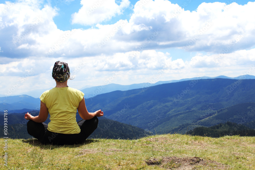 Meditating girl in mountains