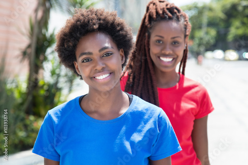 Zwei fröhliche Frauen aus Afrika in bunten Shirts photo