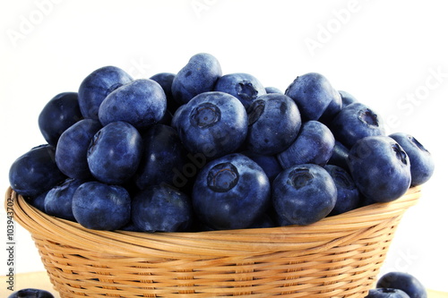 blueberries in bamboo basket on white background
