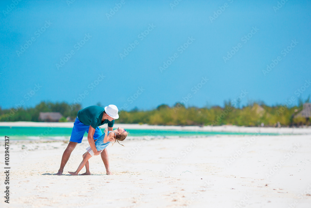 Little girl and young father during tropical beach vacation