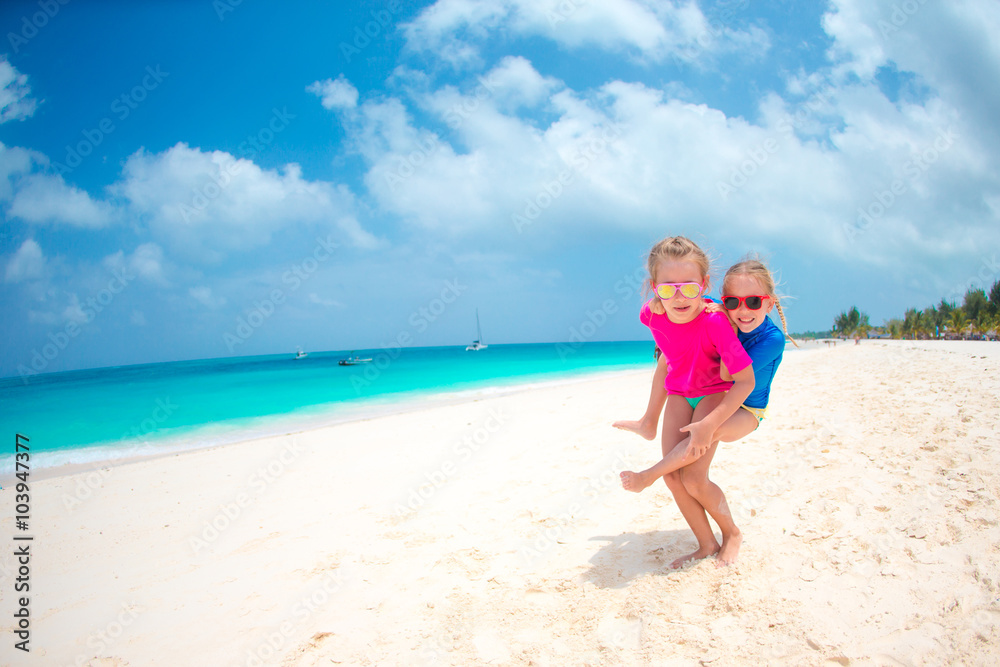 Kids having fun at tropical beach during summer vacation playing together at shallow water