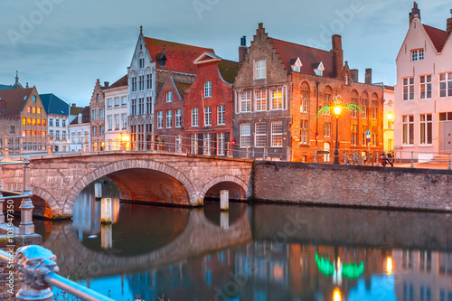 Scenic city view of Bruges canal with beautiful medieval colored houses, bridge and reflections, Belgium