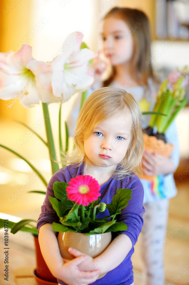 Adorable little girl taking care of plants and flowers Adorable little girl taking care of plants and flowers