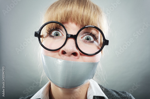 Fotografi Scared woman with mouth taped shut. Censorship.