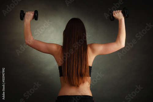 Fit woman exercising with dumbbells. © Voyagerix