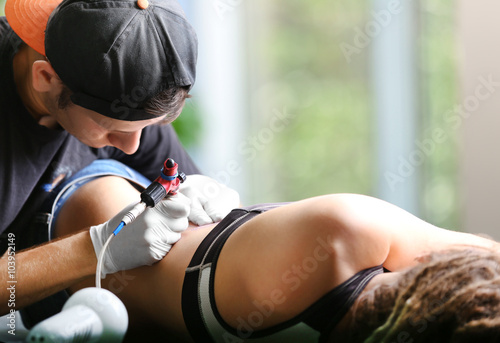 Tattooist makes tattoo, clo...