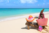 Chair with bag, hat, flip-flops and sunglasses on sunny beach, t