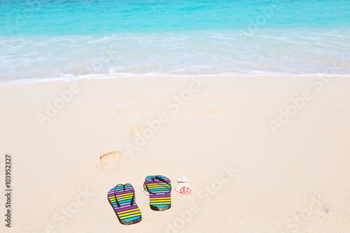 Fototapeta Naklejka Na Ścianę i Meble -  Multicolored flip-flops on a sunny beach..Tropical beach vacatio