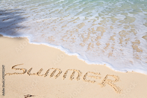 Word SUMMER on beach - vacation concept background