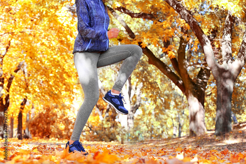 Young woman jogging in autumn park