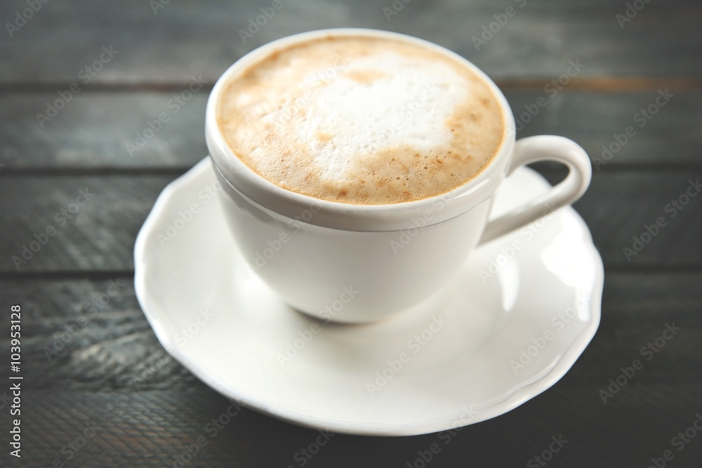 Cup of hot cappuccino with froth on a black wooden table Cup of hot cappuccino with froth on a black wooden table