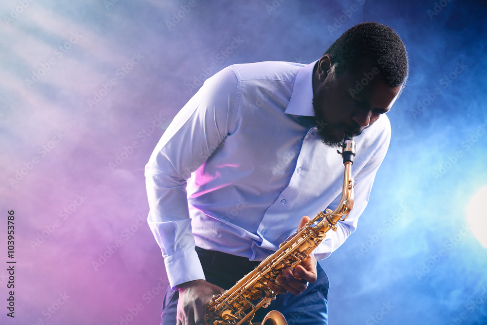 Naklejka premium African American jazz musician playing the saxophone against colorful smoky background