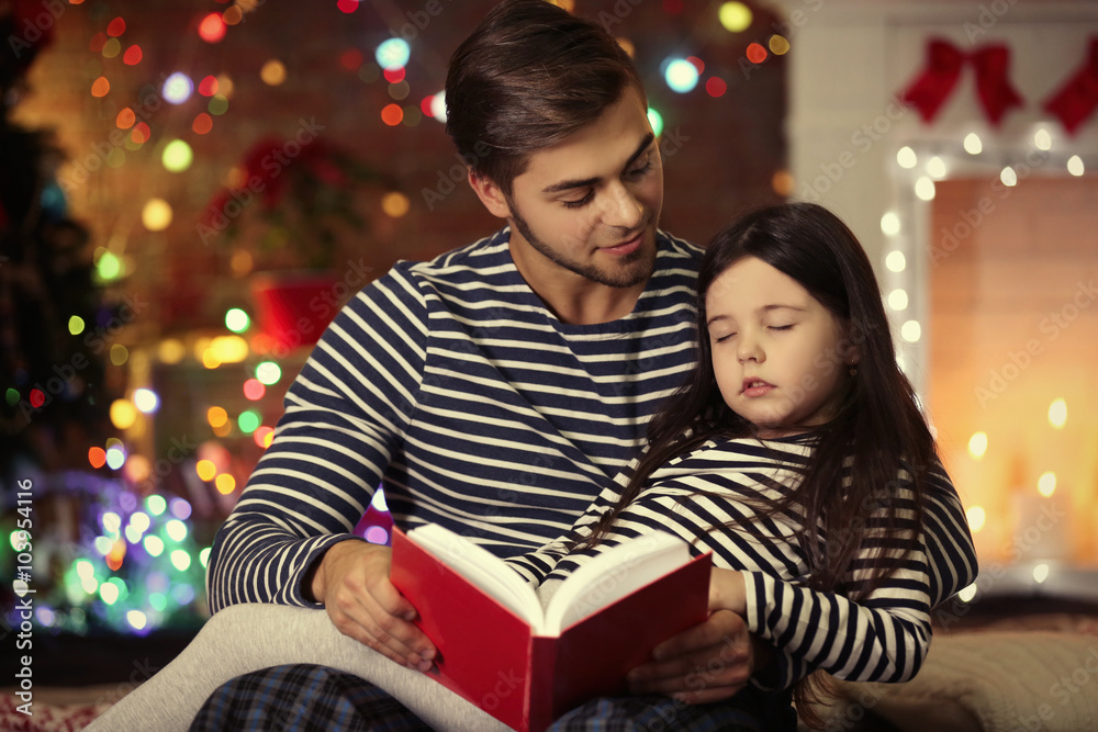 Older brother with little sister reading fairy tale in Christmas living room Older brother with little sister reading fairy tale in Christmas living room