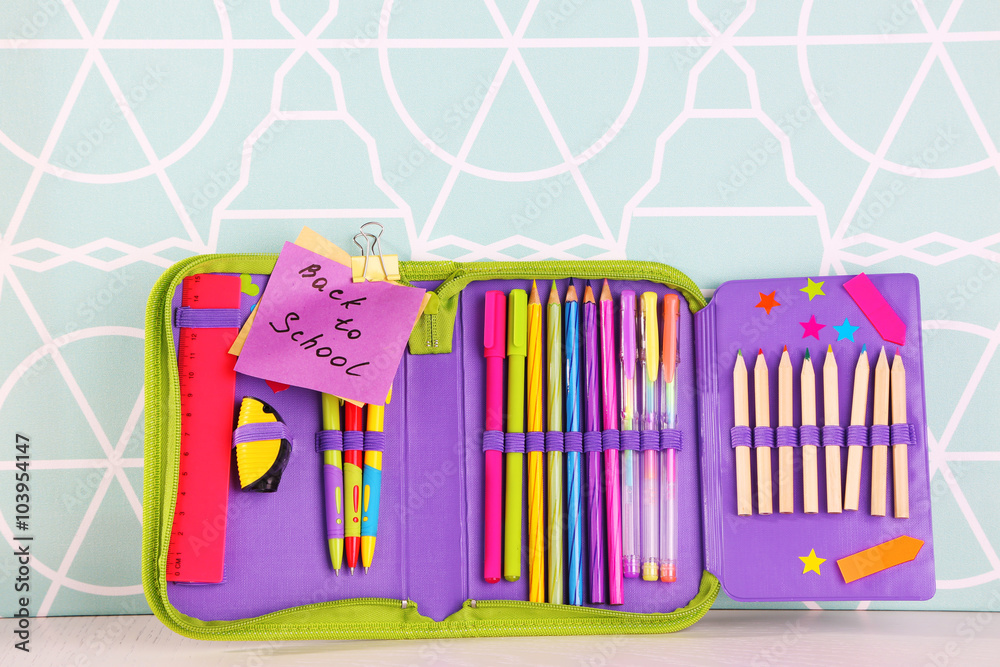Fototapeta premium Pencil case with various stationery on wooden table, close up