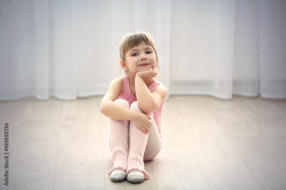Little cute girl in pink leotard sitting on floor at dance studio Little cute girl in pink leotard sitting on floor at dance studio