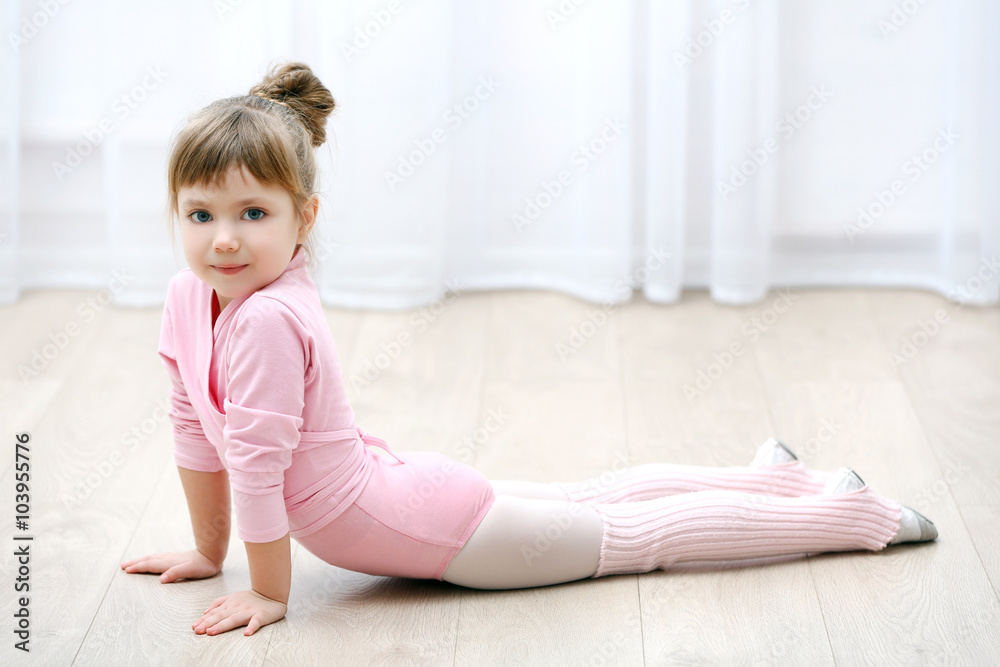 Little cute girl in pink leotard making new ballet movement at dance studio Little cute girl in pink leotard making new ballet movement at dance studio