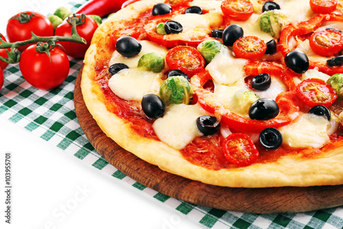 Delicious pizza with cheese and vegetables on green checkered napkin closeup