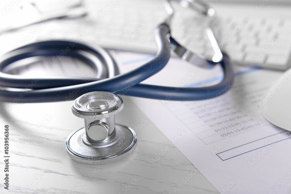 Cardiogram chart with medical stethoscope on table closeup Cardiogram chart with medical stethoscope on table closeup