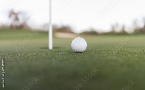  Golf ball close to cup of hole on putting green
