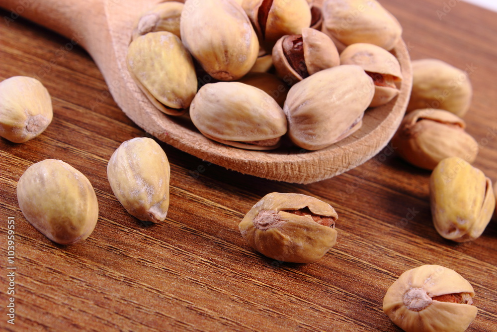 Pistachio nuts with spoon on wooden table, healthy eating Pistachio nuts with spoon on wooden table, healthy eating