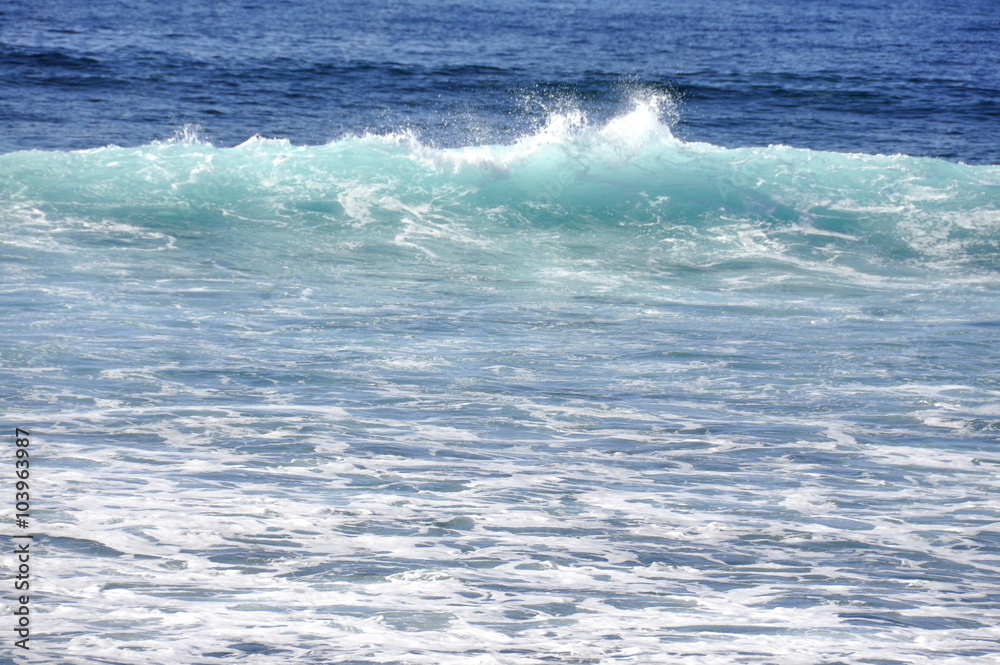 Turquoise wave rolls towards a beach Turquoise wave rolls towards a beach