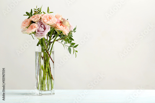 Bouquet of beautiful roses on a blue wooden table
