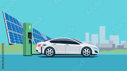 Electric Car Charging at the Charging Station in front of the Solar Panels and Wind Turbines