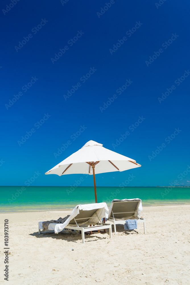 lounge chairs with sun umbrella on a beach lounge chairs with sun umbrella on a beach