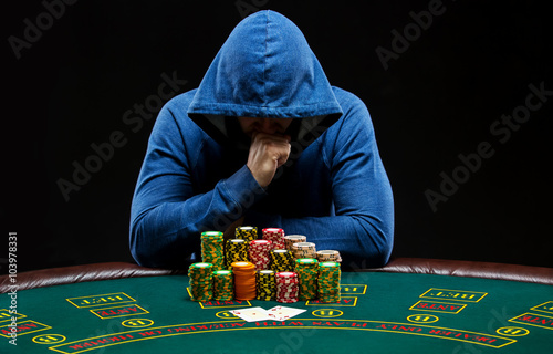 Photography Portrait of a professional poker player sitting at pokers table