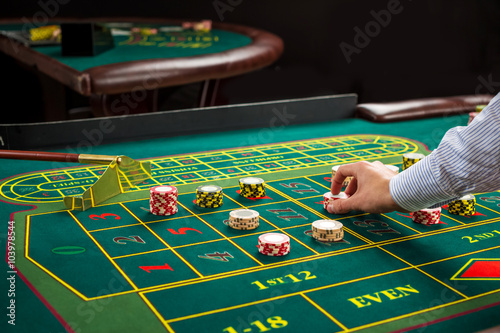 Picture of a green table and betting with chips. 