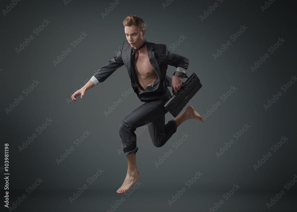 Portrait of a jumping muscular businessman