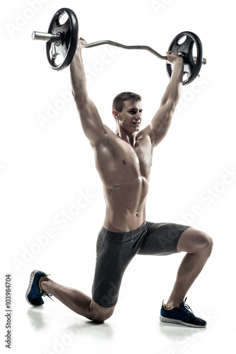 Mighty man standing on knee, holding barbell over his head