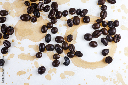 Coffee beans and coffee stains on a white tablecloth.. © peterkai