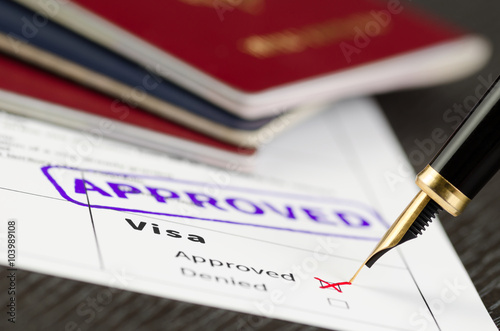 Obraz na plátně Visa application approved, close up shot of a form, passports and pen